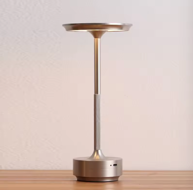 Champagne-gold rechargeable table lamp with warm glowing top and round base