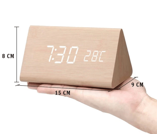 Light wood LED digital clock with white digits, held upright, with size measurements