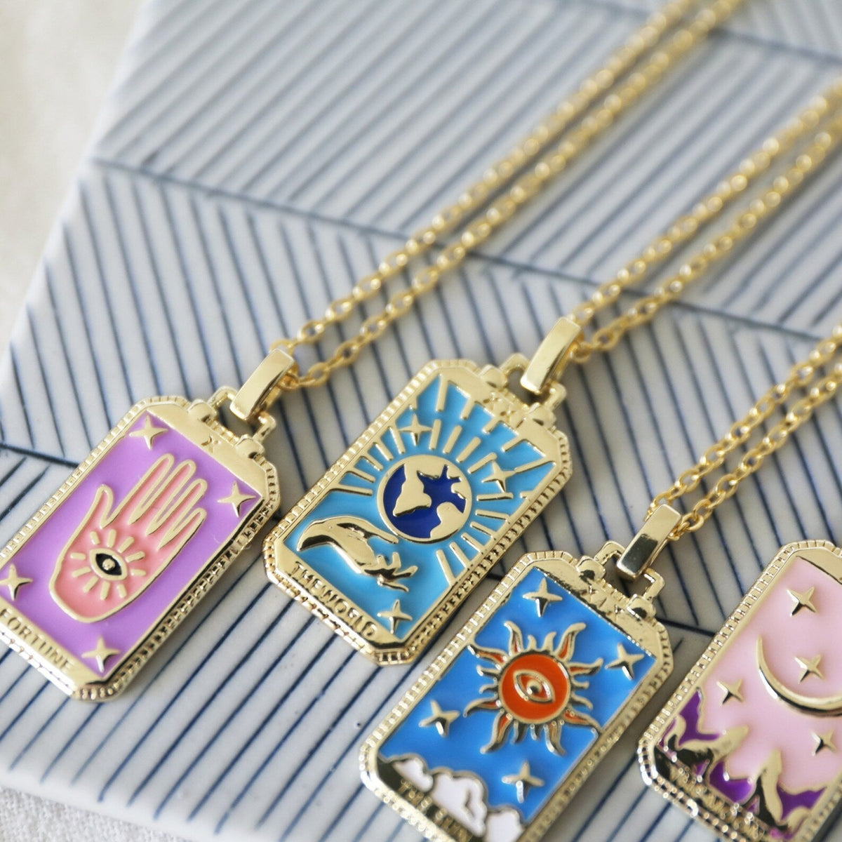 Gold chain tarot pendant necklace with close-up sun, moon, and star card charms
