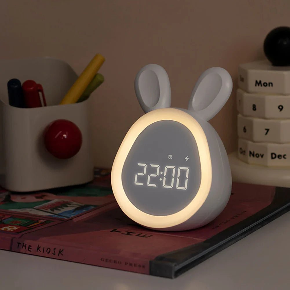 Pink bunny-shaped kids alarm clock with LED night light glowing and digital time display