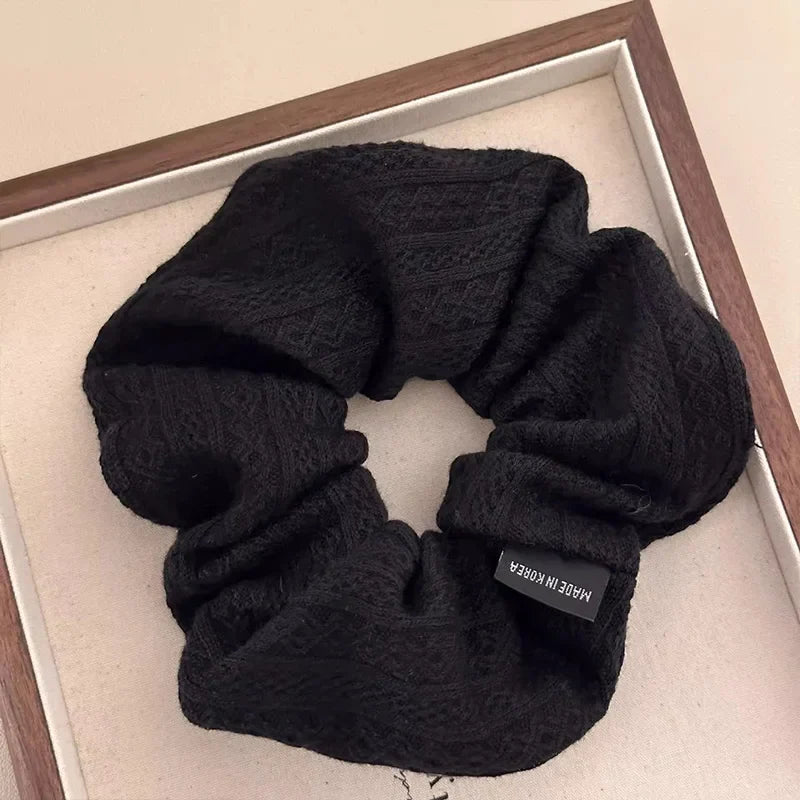 Black knit oversized hair scrunchie with vintage-style pattern and fabric-covered elastic.