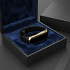 Black activity tracker smartwatch with gold metal frame, shown in a gift box