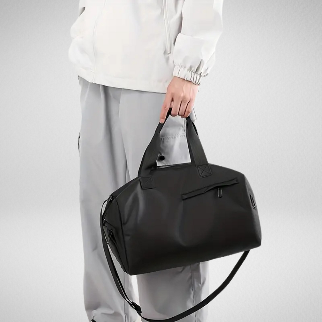 Black water-resistant sports duffel bag with top handles and front zipper pocket