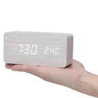 Whitewashed wooden LED digital clock with white digits, held in hand