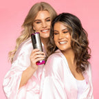 Automatic curling iron in white with pink base, held by two people.