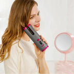 Gray automatic curling iron with pink trim and side control buttons.