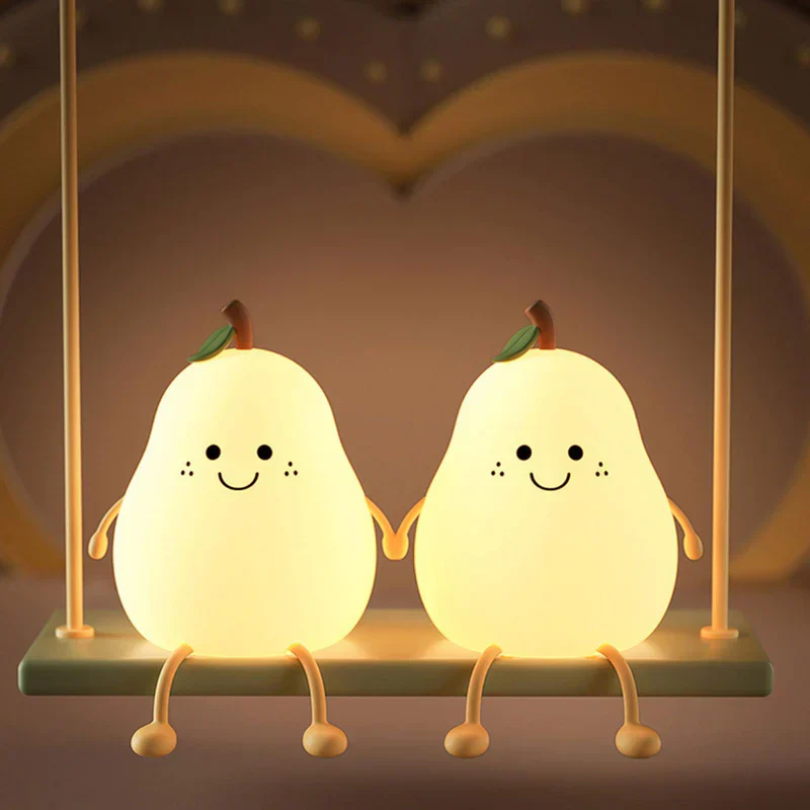 Two glowing pear-shaped night lights with smiling faces and green leaves on stand