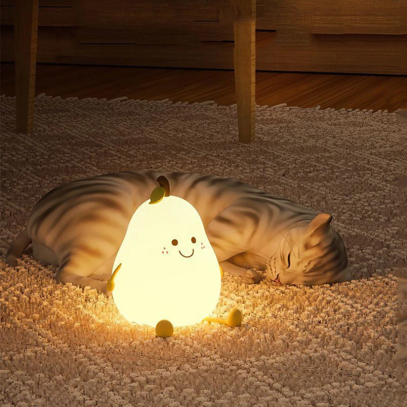 Glowing pear-shaped night light with smiling face and green leaf on bedroom rug