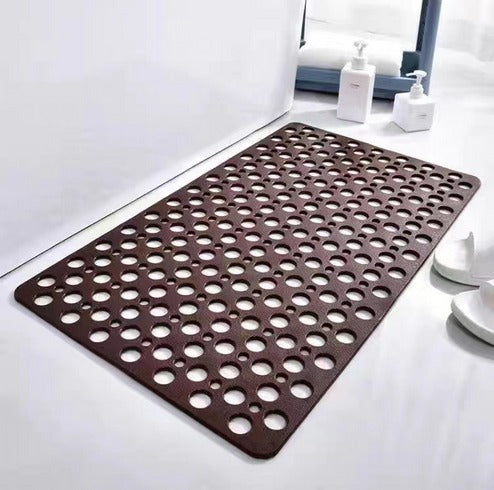 Brown non-slip shower mat with circular drain holes and scalloped edge corners