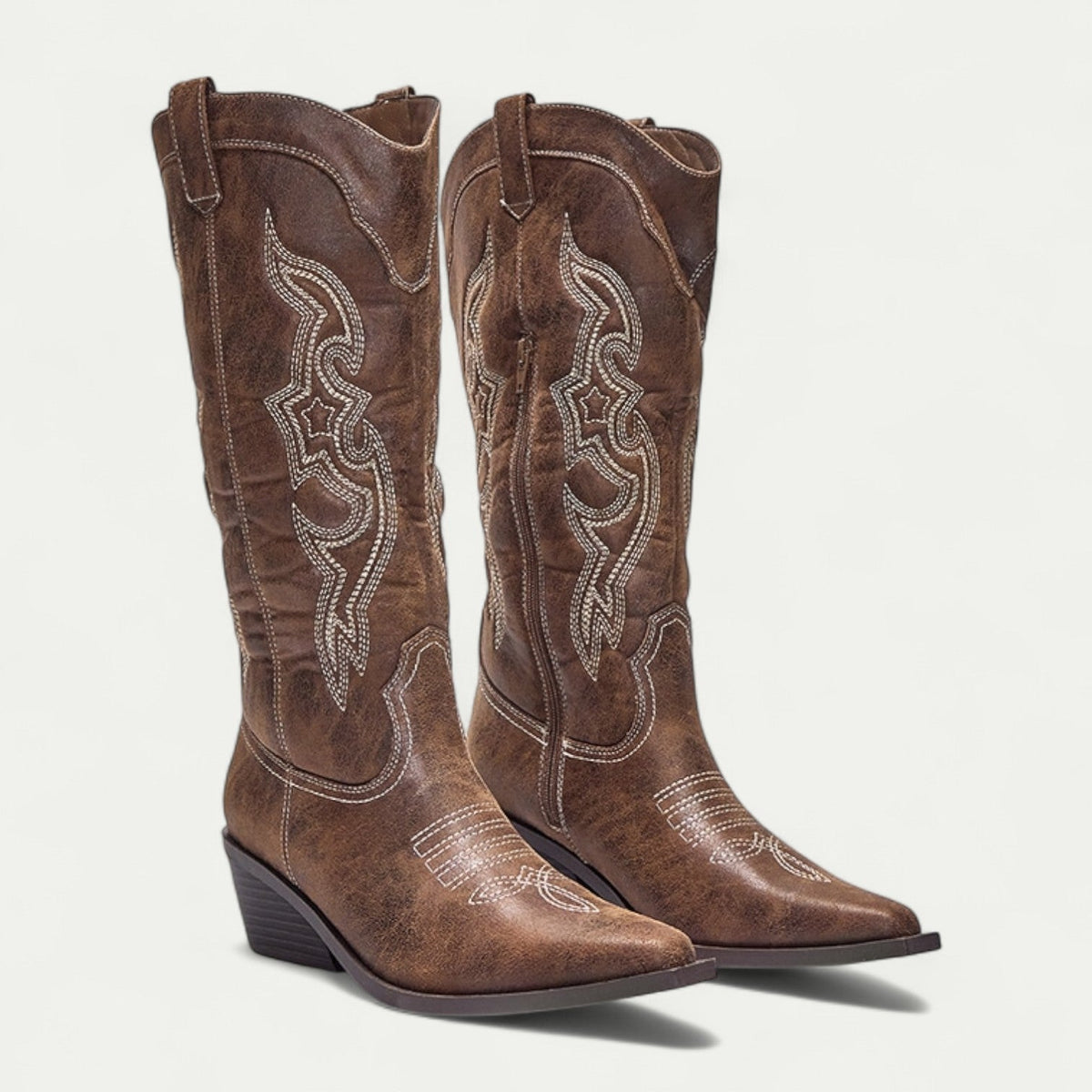 Pair of women's brown boots with pointed toe, pull-on shaft, decorative stitch