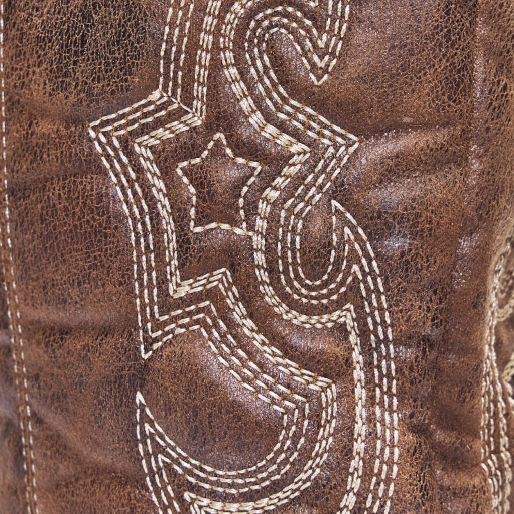 Women's brown boots close-up of ornate white decorative stitching on suede