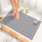 Gray non-slip bath mat with suction cups and ridged drainage slots, rectangular 16x25 in