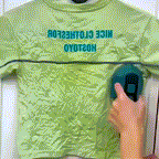 Green mini steam iron steaming a green shirt on a surface