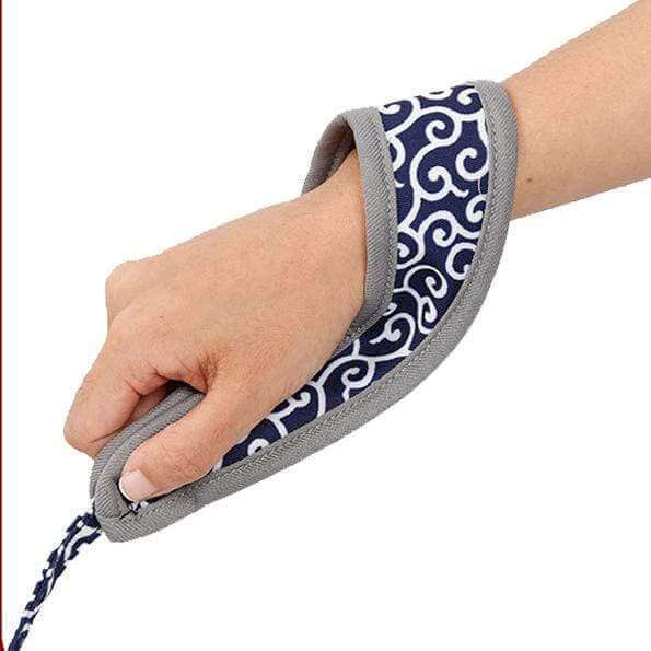 Adjustable cat harness strap with blue patterned fabric and gray trim, held by hand