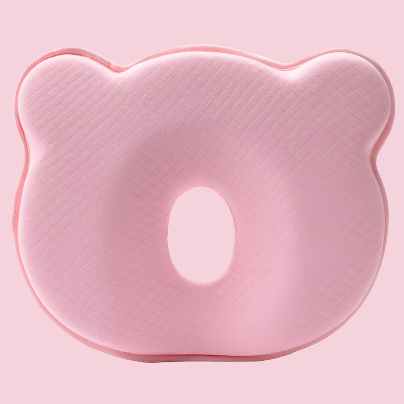 Pink contoured baby head support pillow close-up with oval face cutout