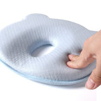 Contoured baby head support pillow in light blue-gray with oval face cutout