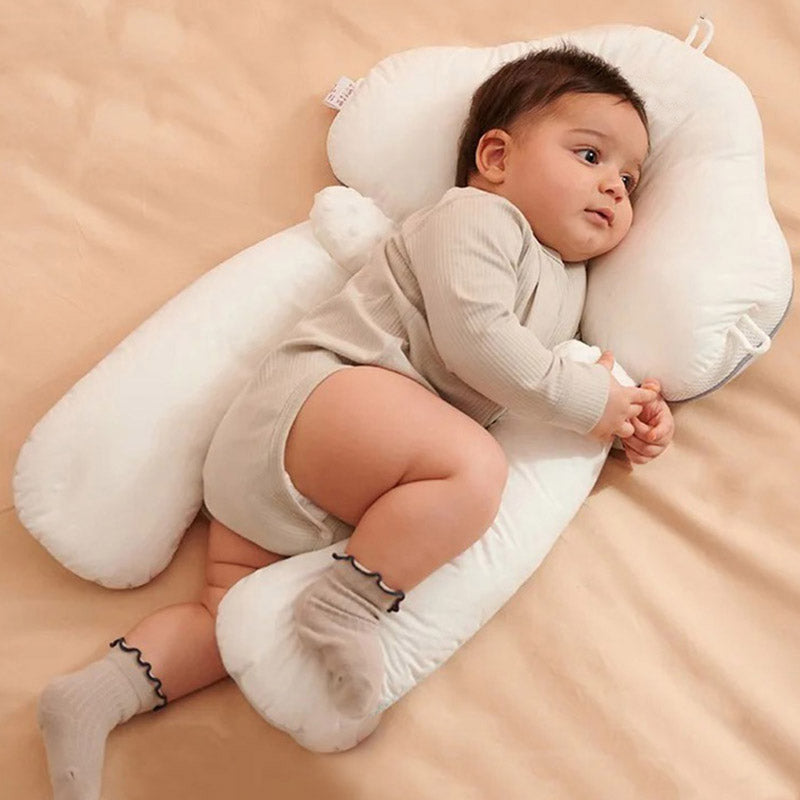 White ergonomic baby cushion supporting a baby lying sideways