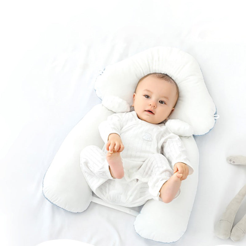 White ergonomic baby cushion with plush neck support, baby lying inside