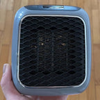 Compact electric fan heater front grille with black honeycomb pattern and silver frame