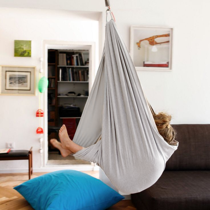 Gray kids' cotton hammock swing cocoon suspended, child reclining with legs out.