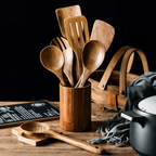 Natural unfinished wooden cooking utensils set in a cylindrical wooden holder