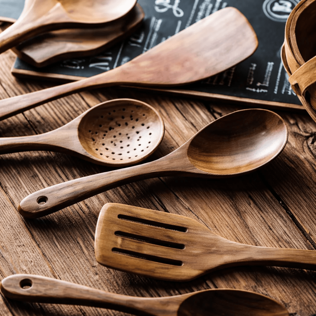 Natural wooden spoons and ladles with holes on a rustic wooden surface