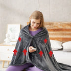 Dark gray heated throw with hood and front opening, with controller held in hand