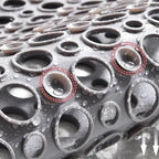 Close-up of gray shower mat drain holes with water droplets for grip