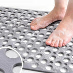 Gray non-slip shower mat with drainage holes for secure wet-foot placement.