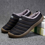Men's lined slip-on slippers in black with faux-fur lining, striped seams, and rubber sole