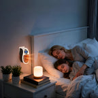 Wall plug-in heater with orange glowing core beside a nightstand
