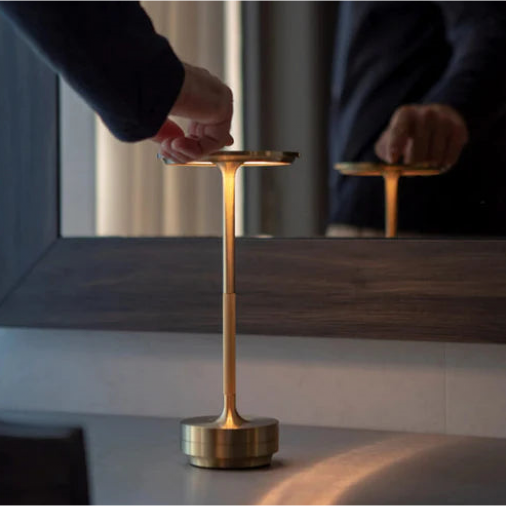 Touch-controlled rechargeable table lamp with warm glow on gold stem and base
