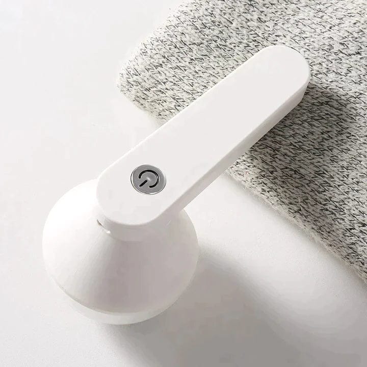 Rechargeable fabric shaver, white handheld lint remover on grey knitted cloth