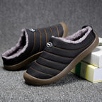 Men's lined slip-on slippers in black with faux-fur interior and textured brown rubber sole