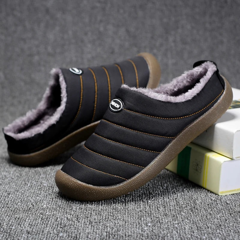 Men's lined slip-on slippers in black with faux-fur interior and textured brown rubber sole