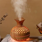 Aroma diffuser with carved wood-look body, warm orange glowing lattice LED light