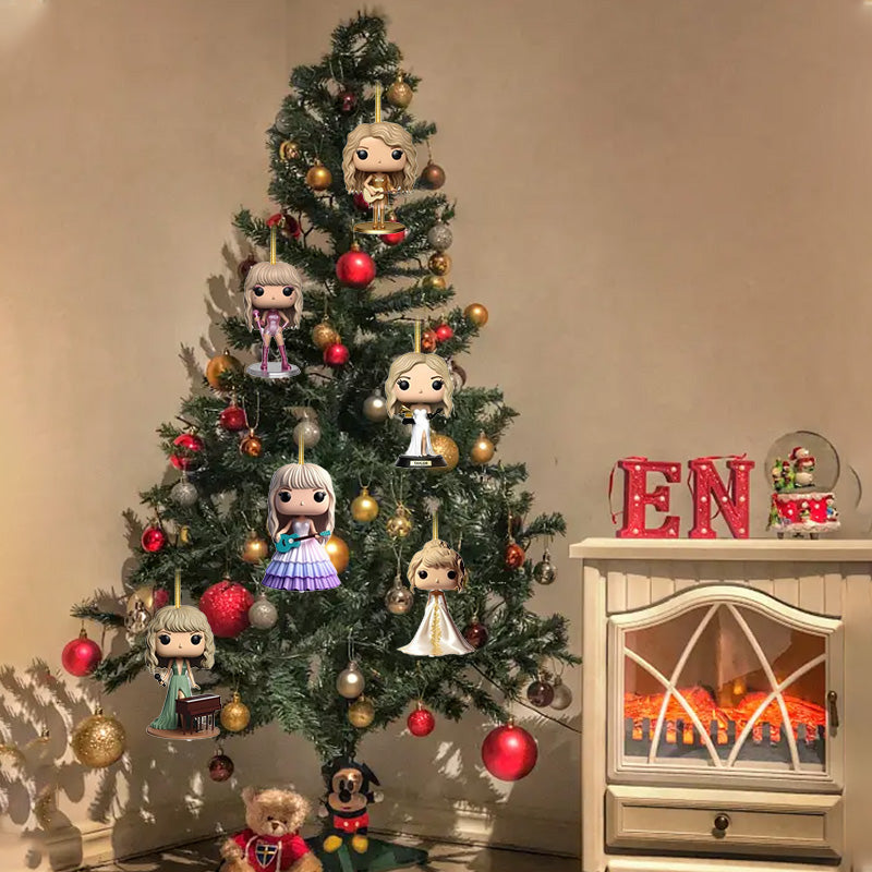 Pop star 2D charm figures hanging on a Christmas tree near a fireplace