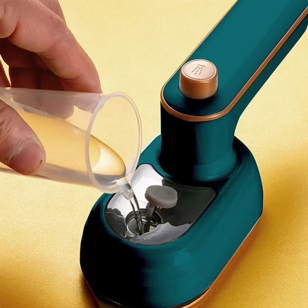 Green mini steam iron dispensing steam from water tank opening